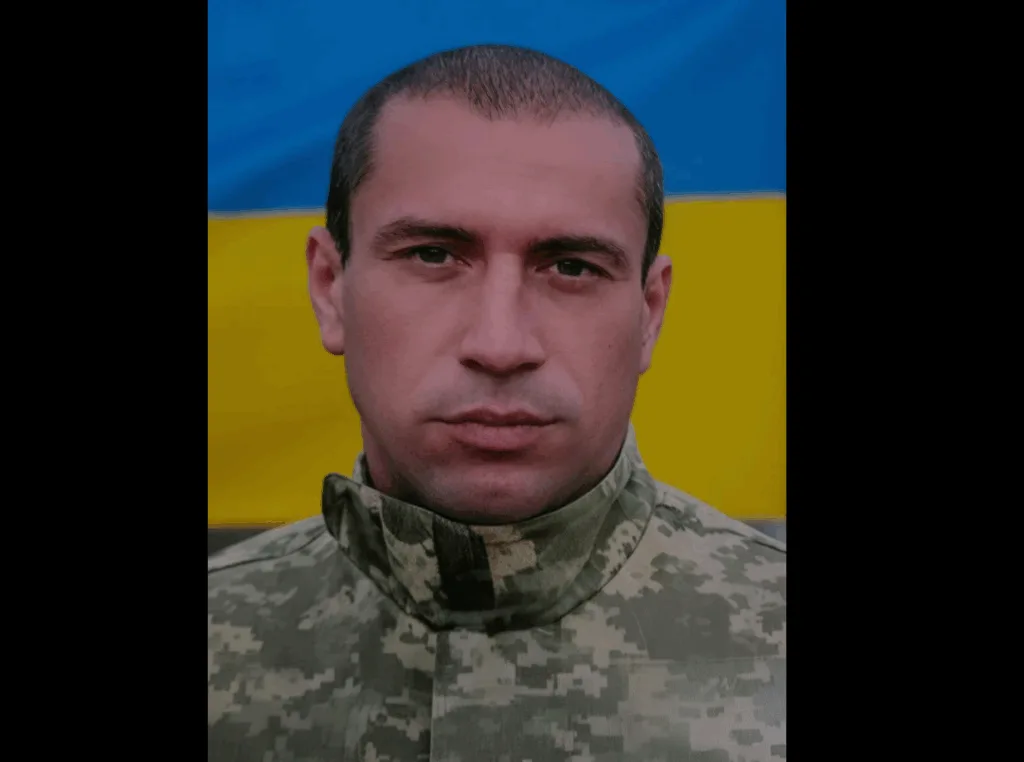 Український військовий перед прапором України