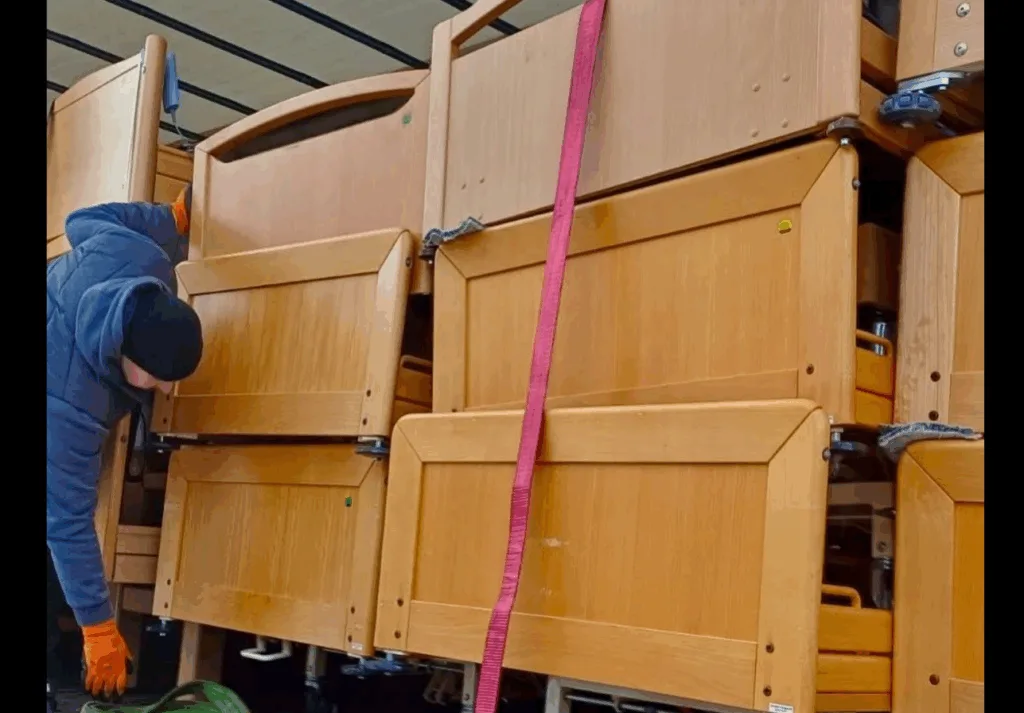 Завантаження дерев'яних ліжок у вантажівку
