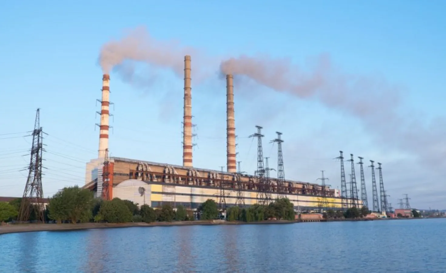 Теплова електростанція біля води з димом