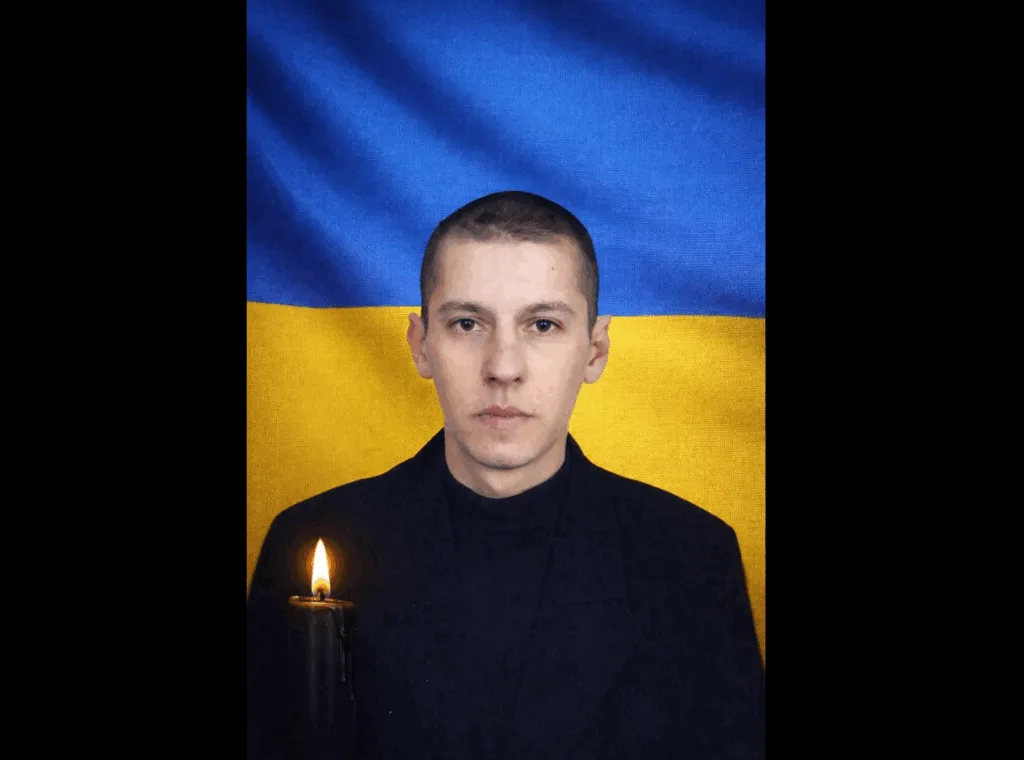 Чоловік із свічкою перед прапором України