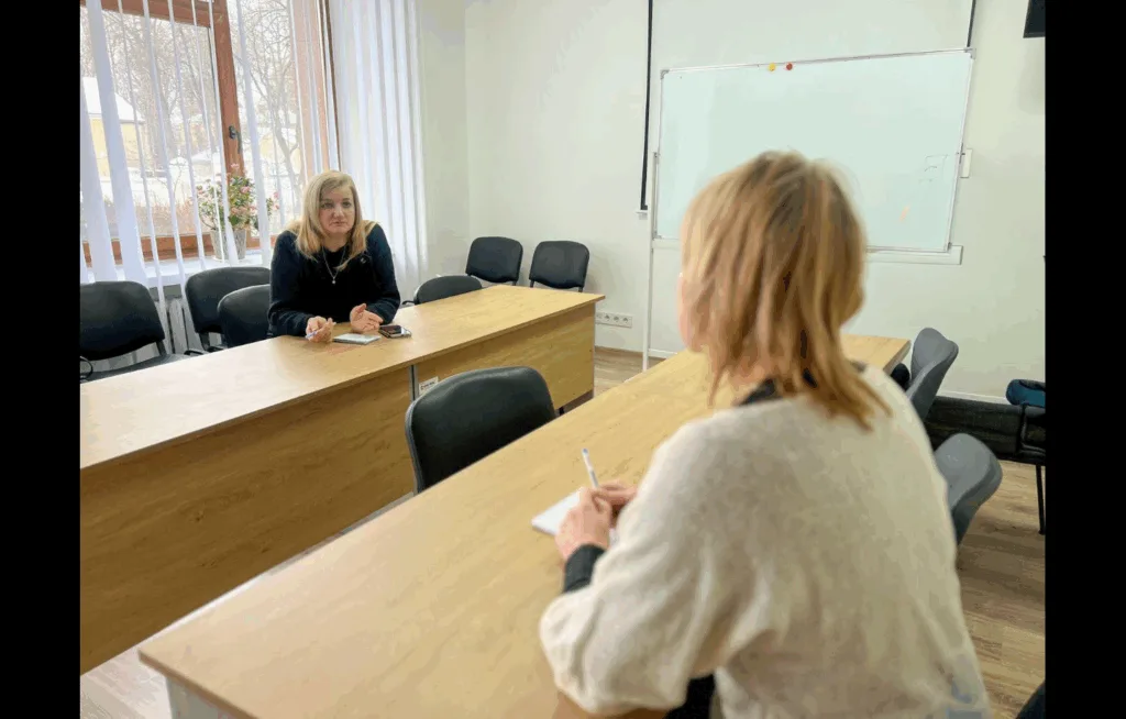 Дві жінки розмовляють у навчальній аудиторії