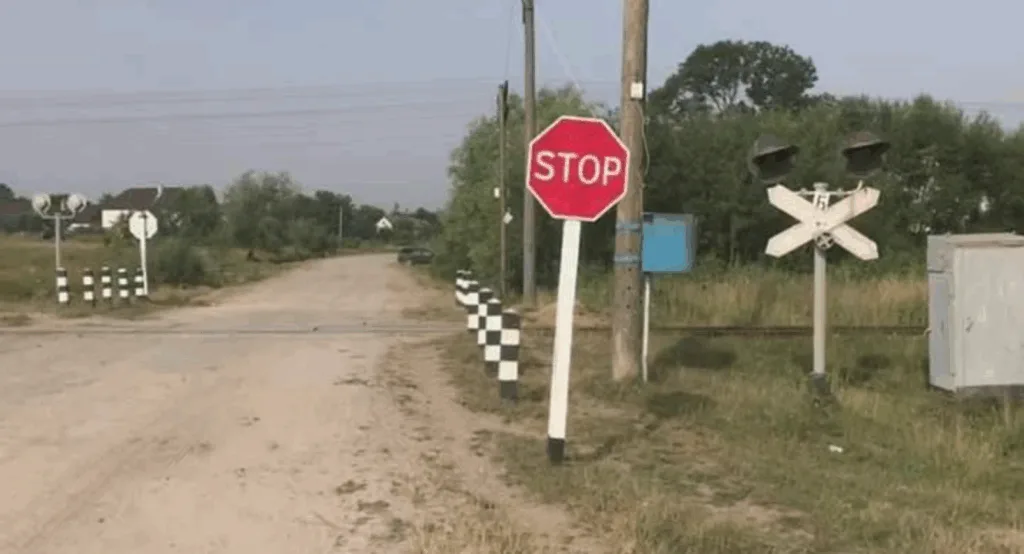 Залізничний переїзд із знаком стоп на сільській дорозі