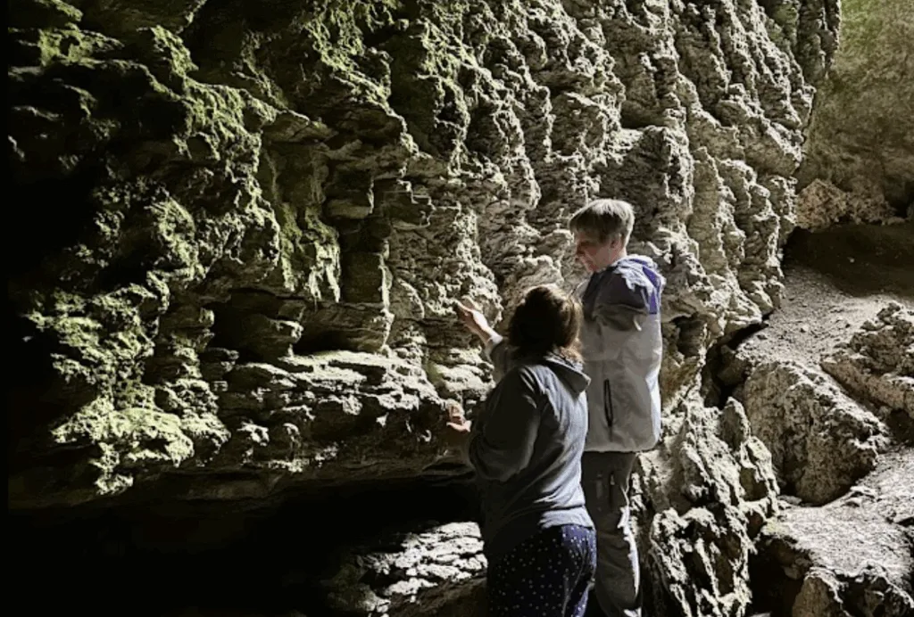 Люди досліджують стіни в кам’яній печері