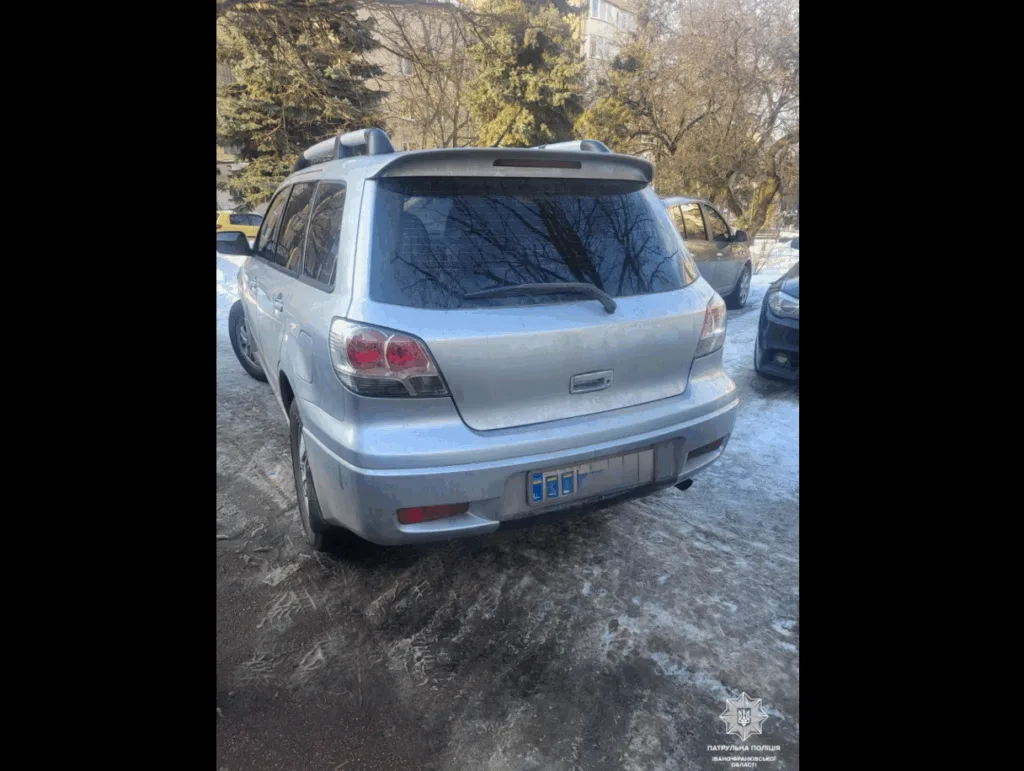 Сріблястий позашляховик припаркований на засніженій вулиці