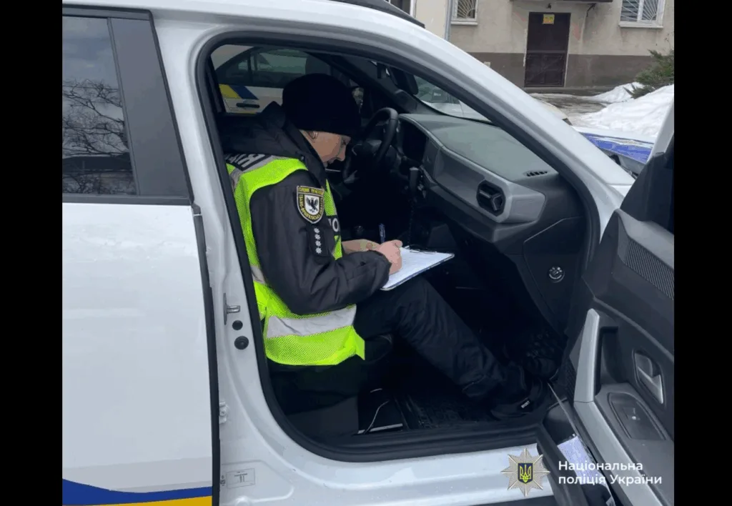 Поліцейський пише звіт у службовому автомобілі