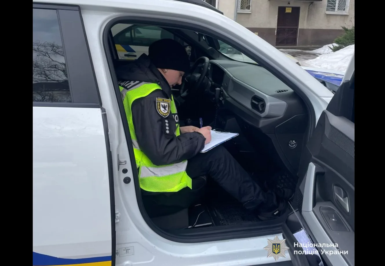 Поліцейський пише звіт у службовому автомобілі