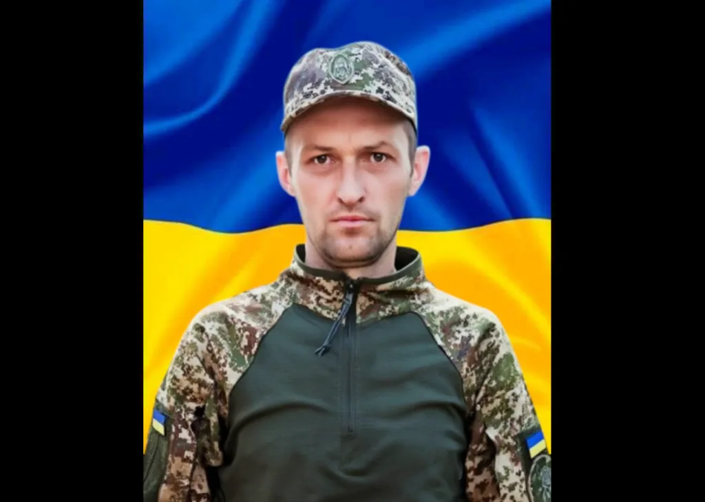 Український військовий на фоні прапора України