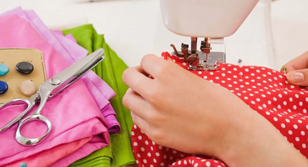 Шиття червоної тканини на швейній машинці