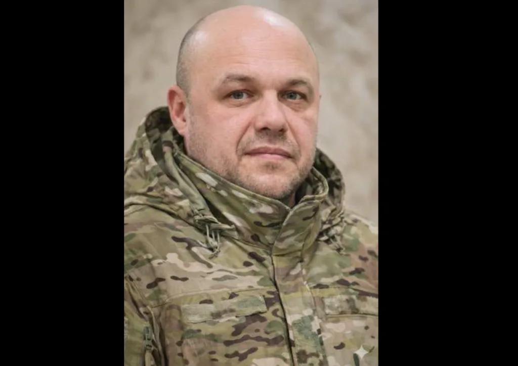 Чоловік у камуфляжній куртці дивиться в камеру