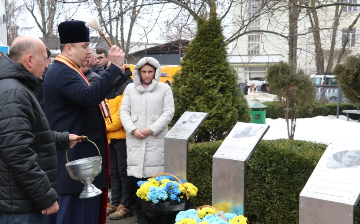 Освячення меморіалу з квітами у зимовому парку