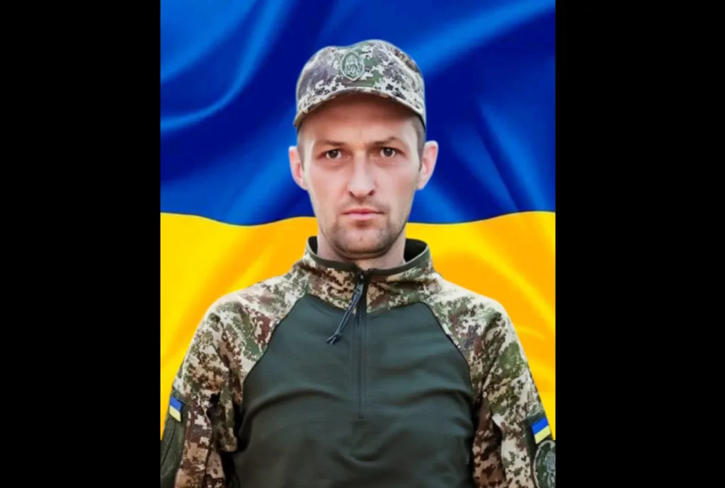 Український військовий на фоні прапора України