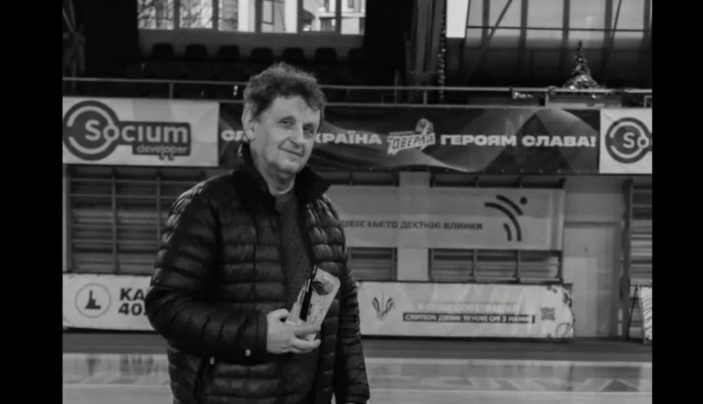 Чоловік тримає нагороду в спортивному залі