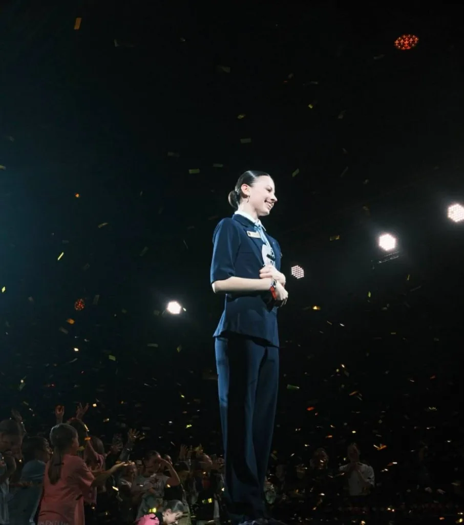 Жінка на сцені під оплески аудиторії