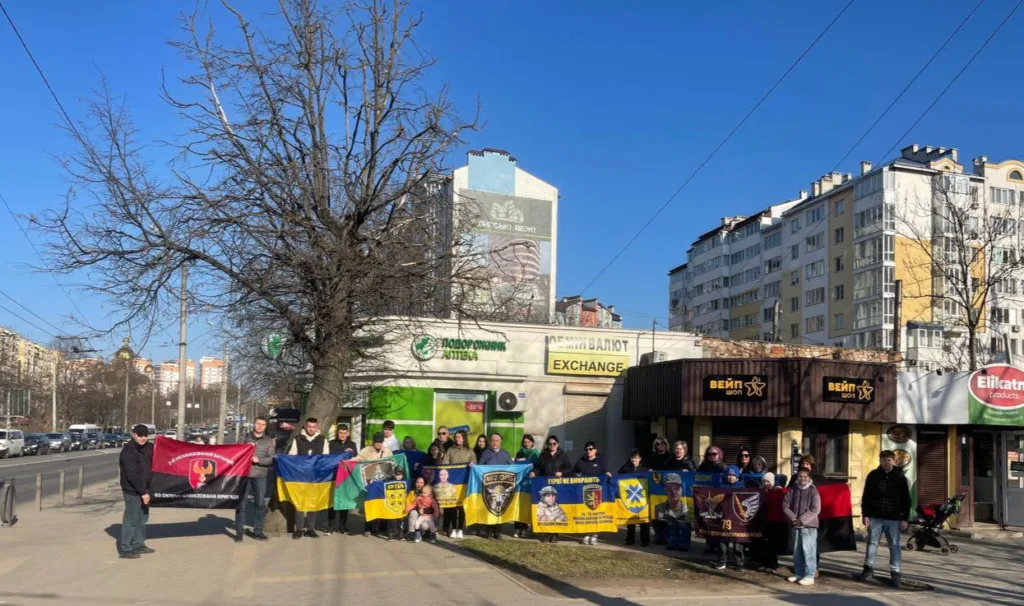 Люди з українськими прапорами на міській вулиці