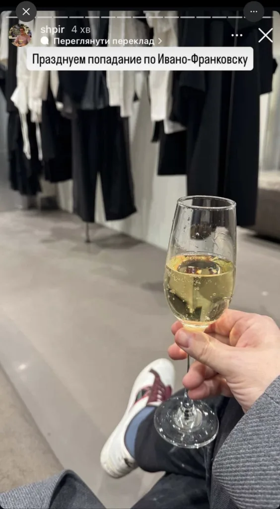 Людина тримає келих ігристого вина у магазині