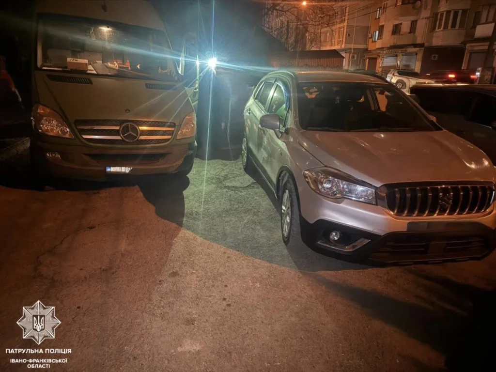 Два автомобілі припарковані на вулиці вночі