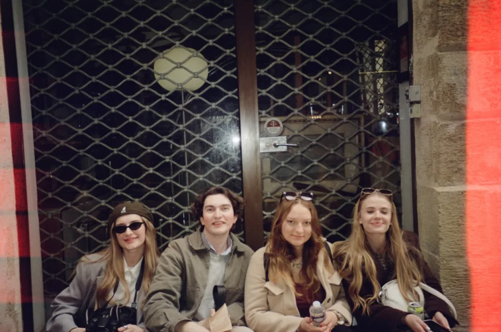 Четверо друзів сидять біля зачинених воріт