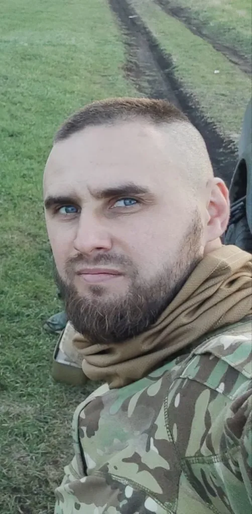 Військовий у камуфляжі на зеленому полі