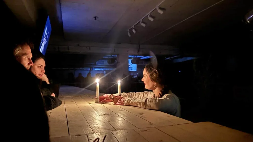 Люди розмовляють при свічках у темній кімнаті