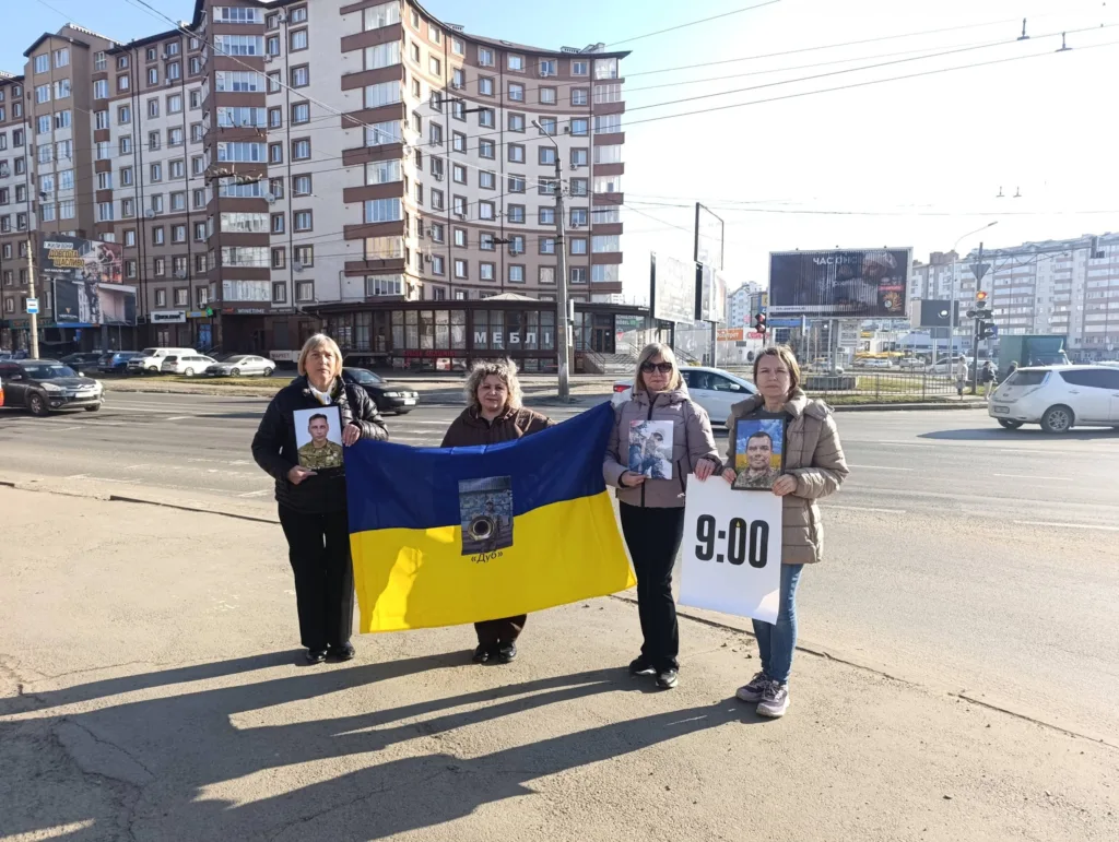 Жінки з українським прапором і фото військових