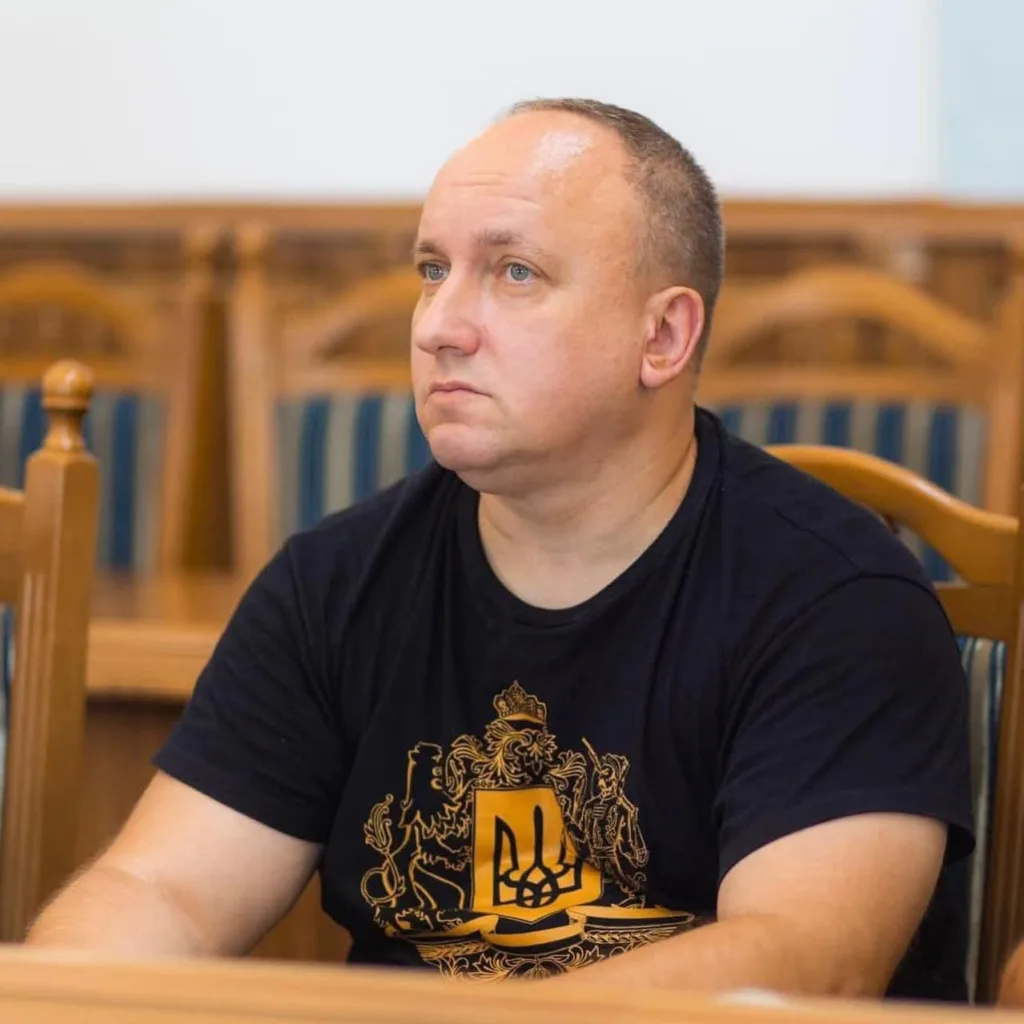 Чоловік у чорній футболці з українським гербом