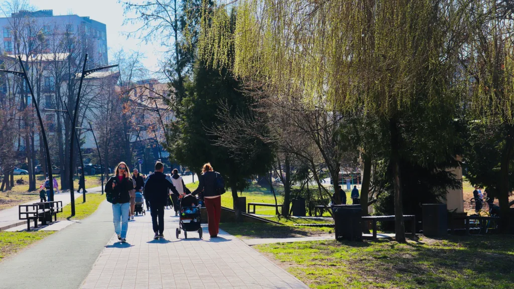 Люди прогулюються парком навесні