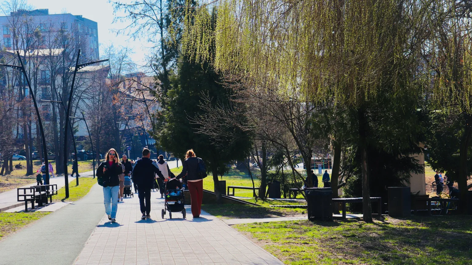 Люди прогулюються парком навесні