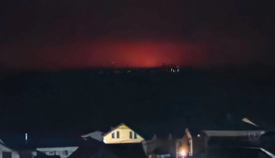 Нічне небо з червоним сяйвом над містом