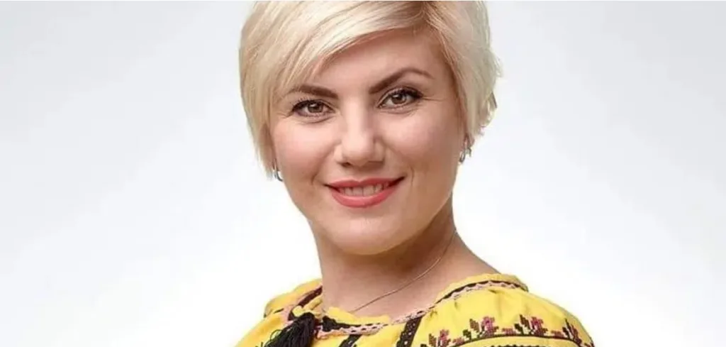 Жінка у жовтій вишиванці усміхається