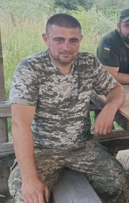 Військовий у камуфляжі сидить на лавці