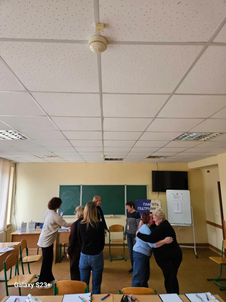 Люди спілкуються в навчальній аудиторії біля дошки