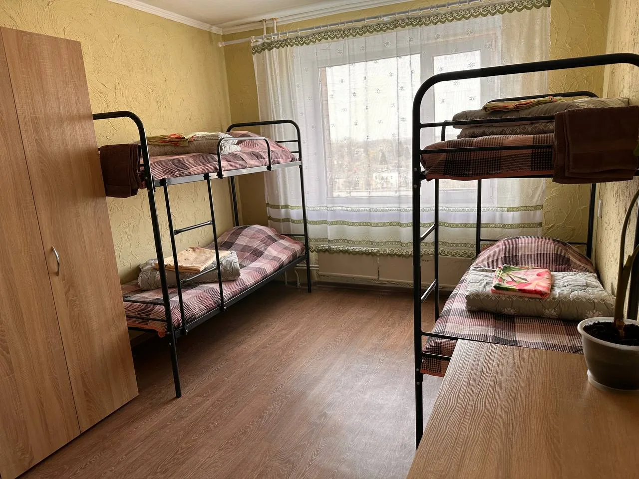 Кімната гуртожитку з двоярусними ліжками та шафою