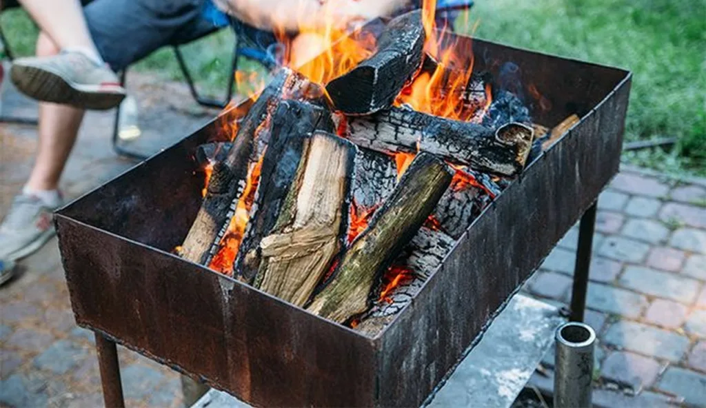 Вогонь у мангалі з палаючими дровами