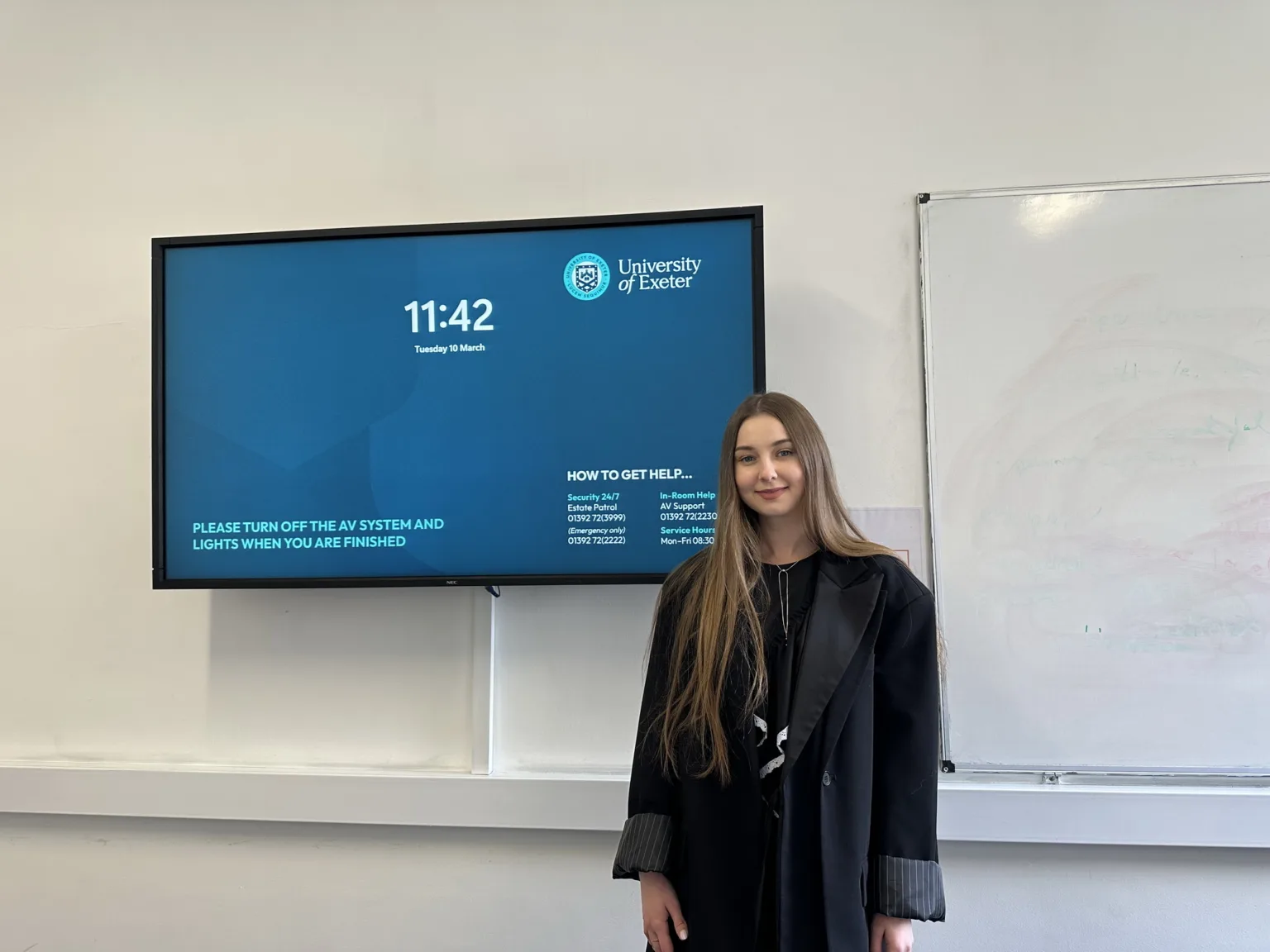Студентка перед екраном Університету Ексетера