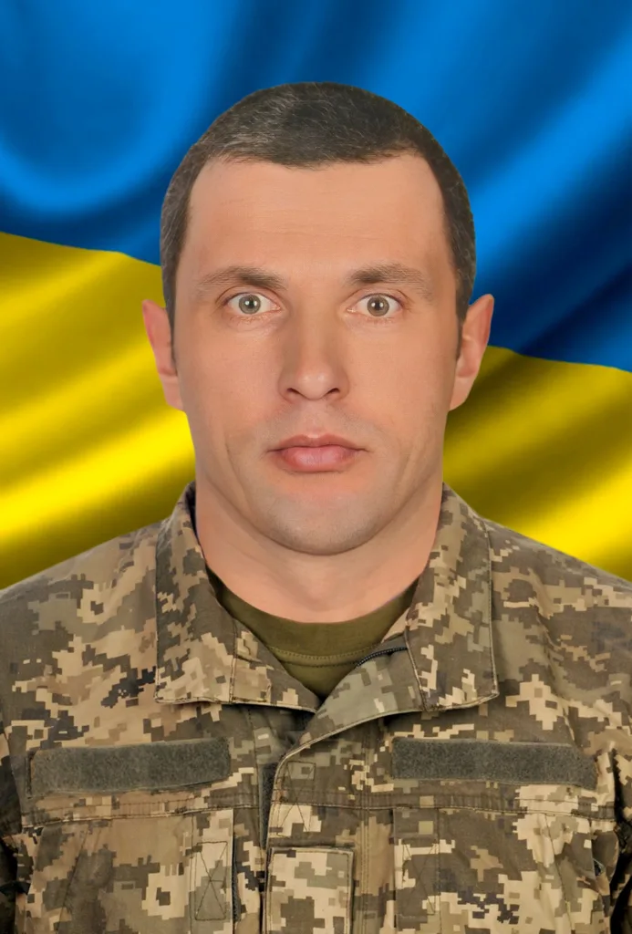 Військовий у формі на тлі прапора України