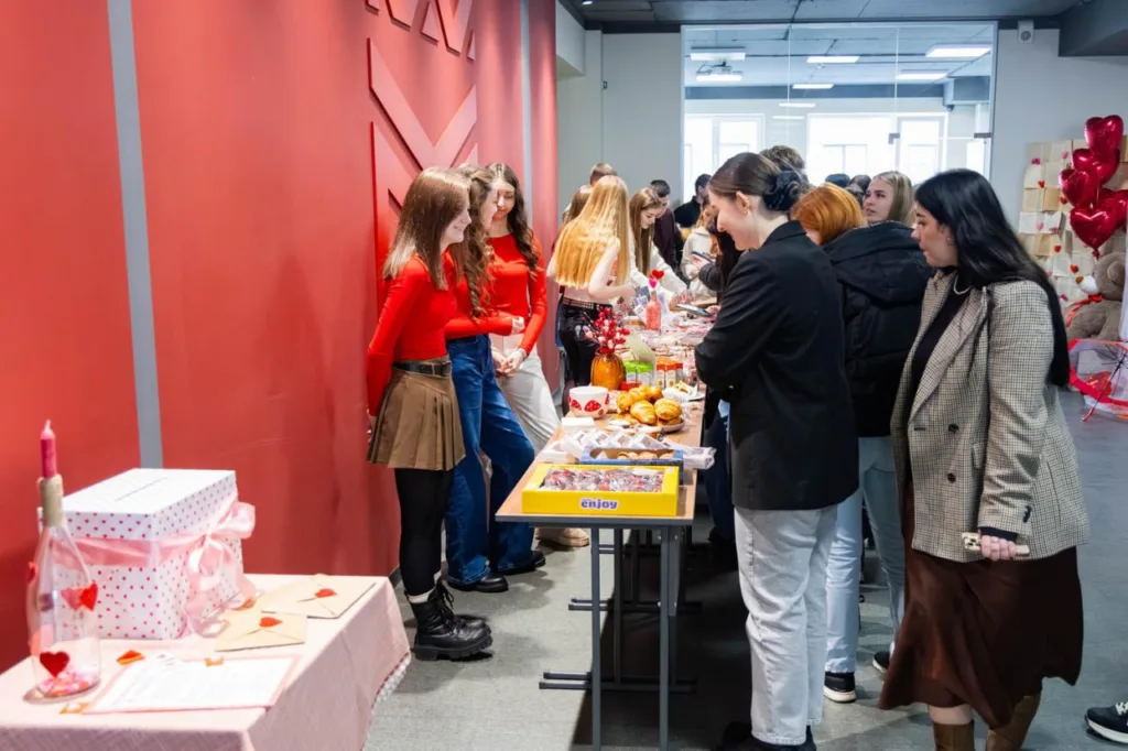 Студенти спілкуються біля столу з випічкою