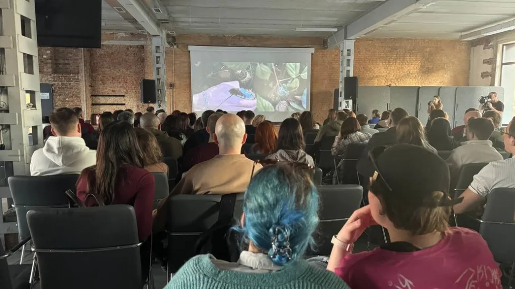 Люди дивляться фільм у великій залі