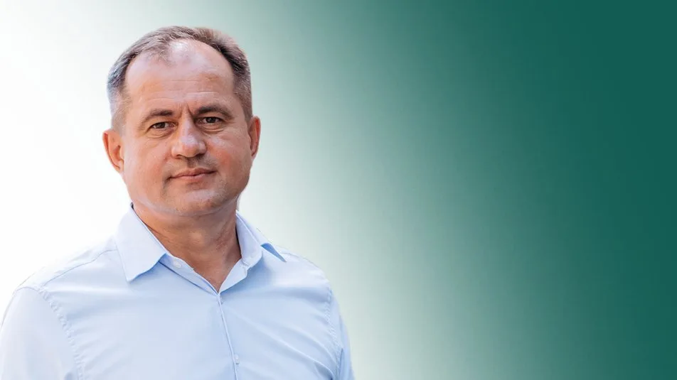 Чоловік у світлій сорочці на зеленому тлі