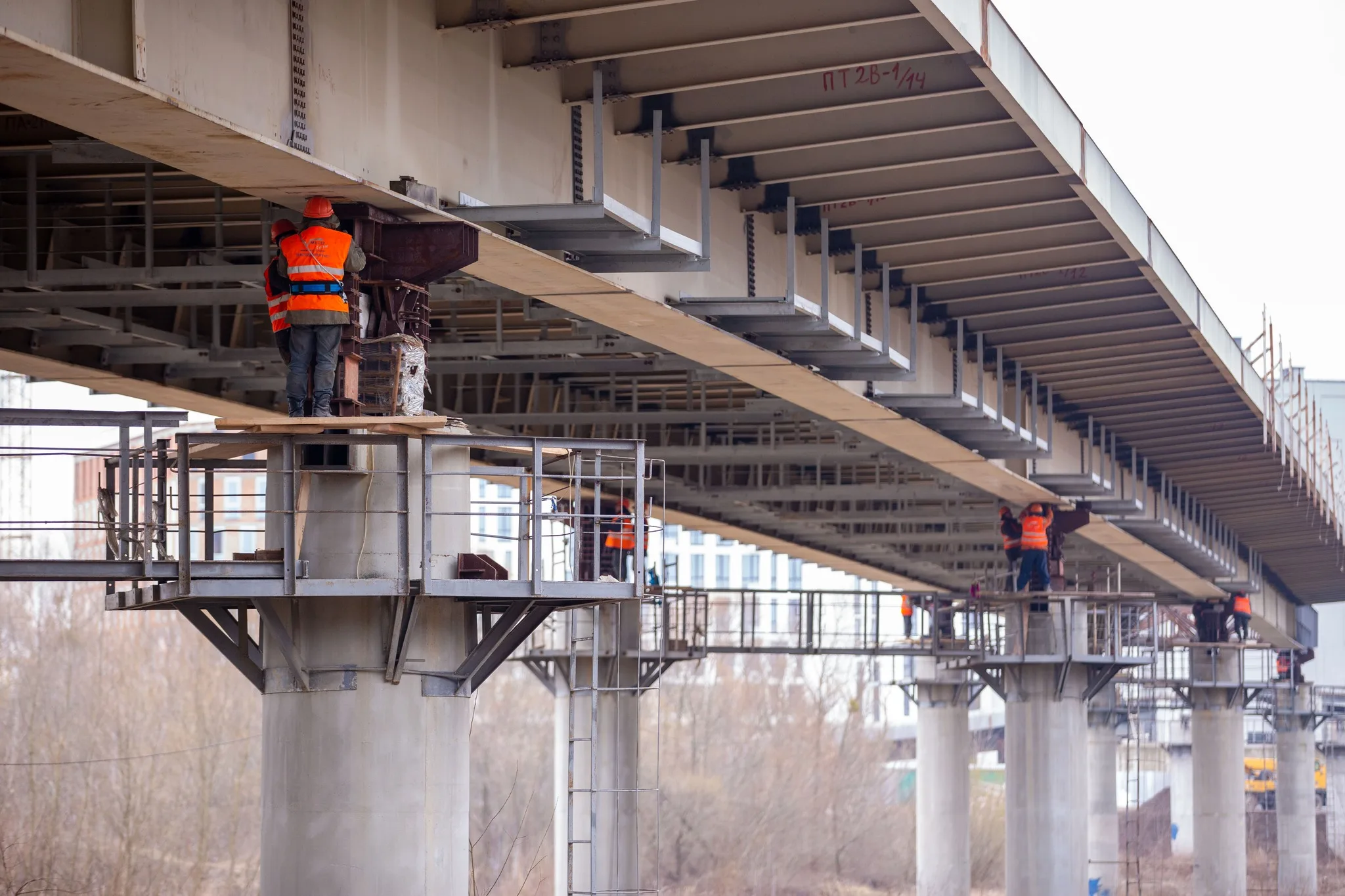 Будівельники працюють під мостом над річкою