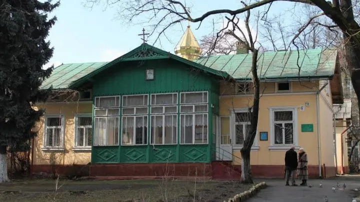 Старовинна будівля з зеленою покрівлею в Україні