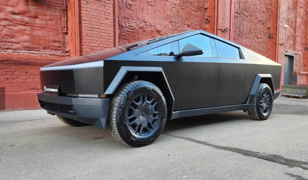 Сучасний електричний пікап біля червоної цегляної стіни