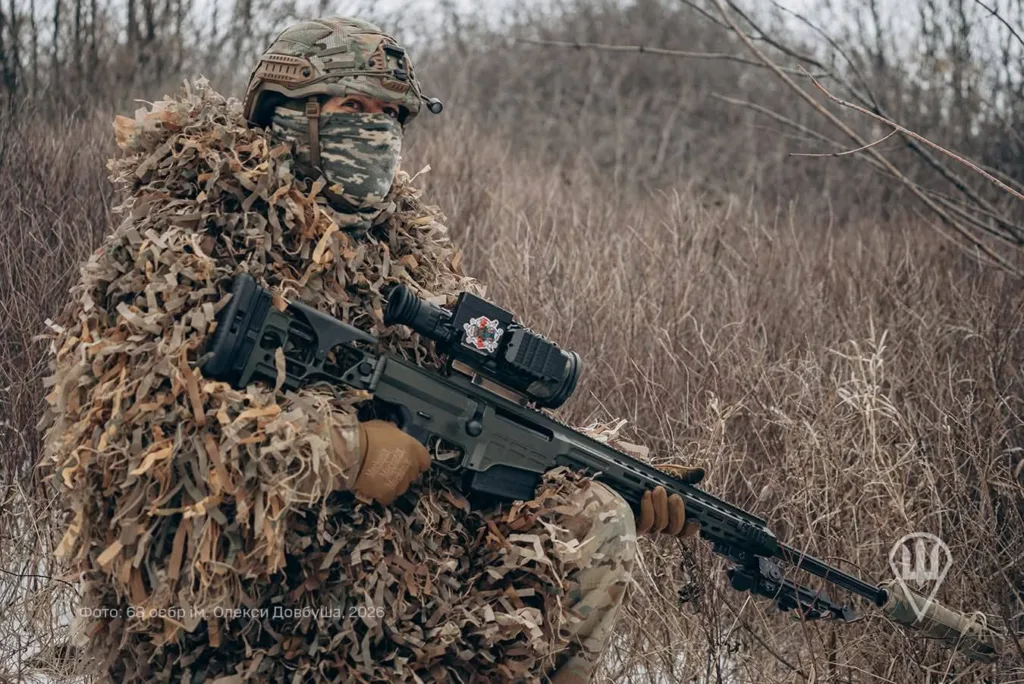 Снайпер у камуфляжі в зимовому лісі