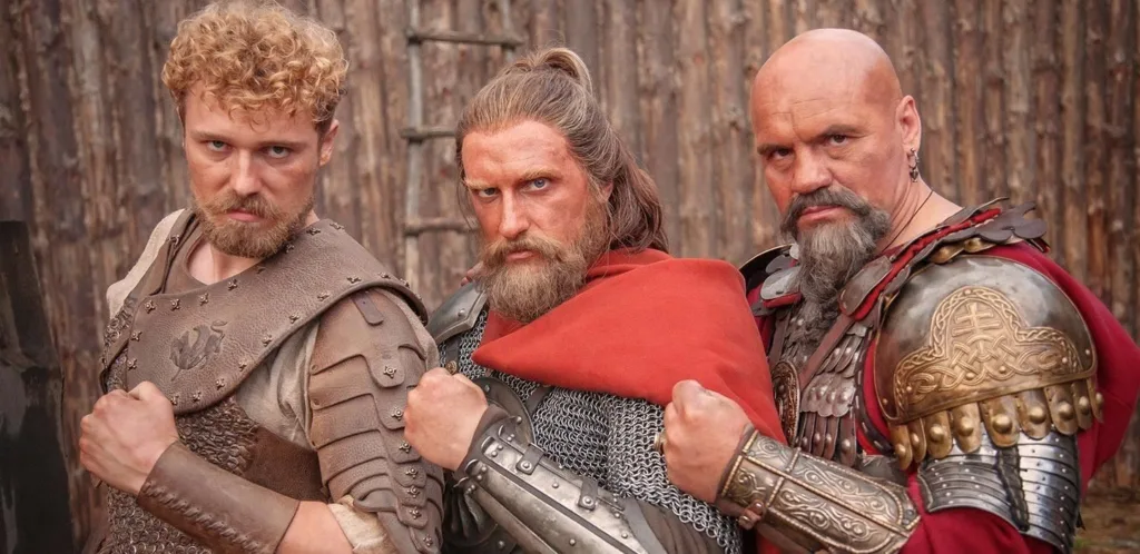 Три воїни у середньовічних обладунках позують разом