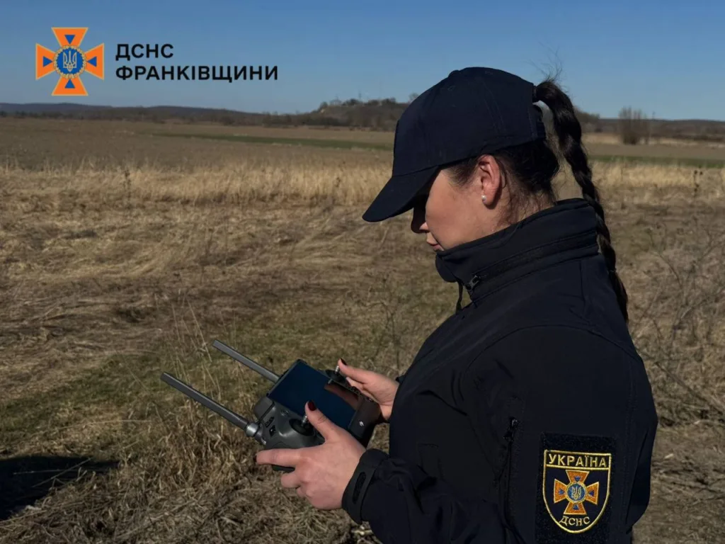 Рятувальниця ДСНС керує дроном у полі