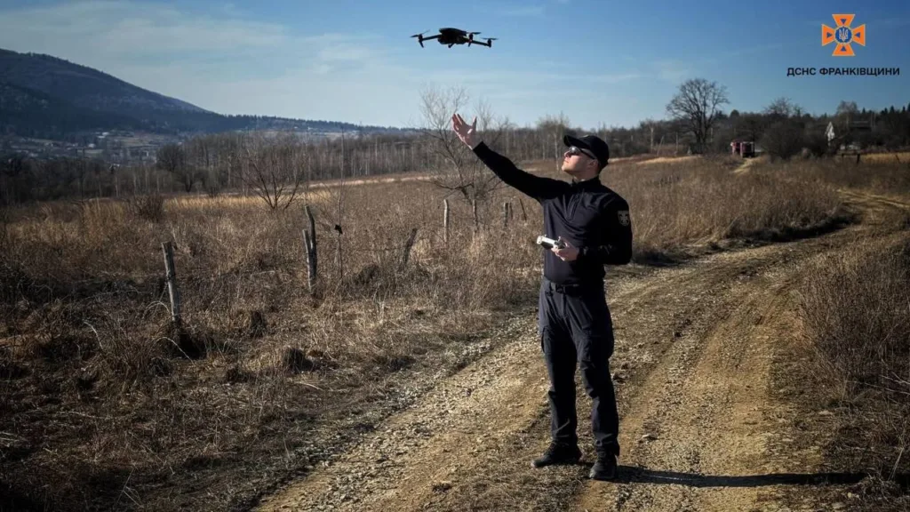 Рятувальник керує дроном у сільській місцевості