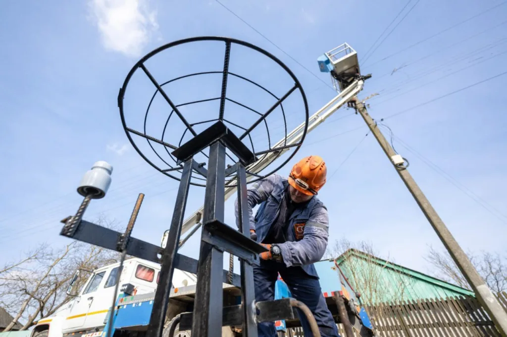 Робітник встановлює металеву конструкцію під сонячну антену