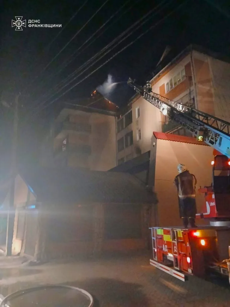 Пожежники гасять вогонь на даху будинку вночі