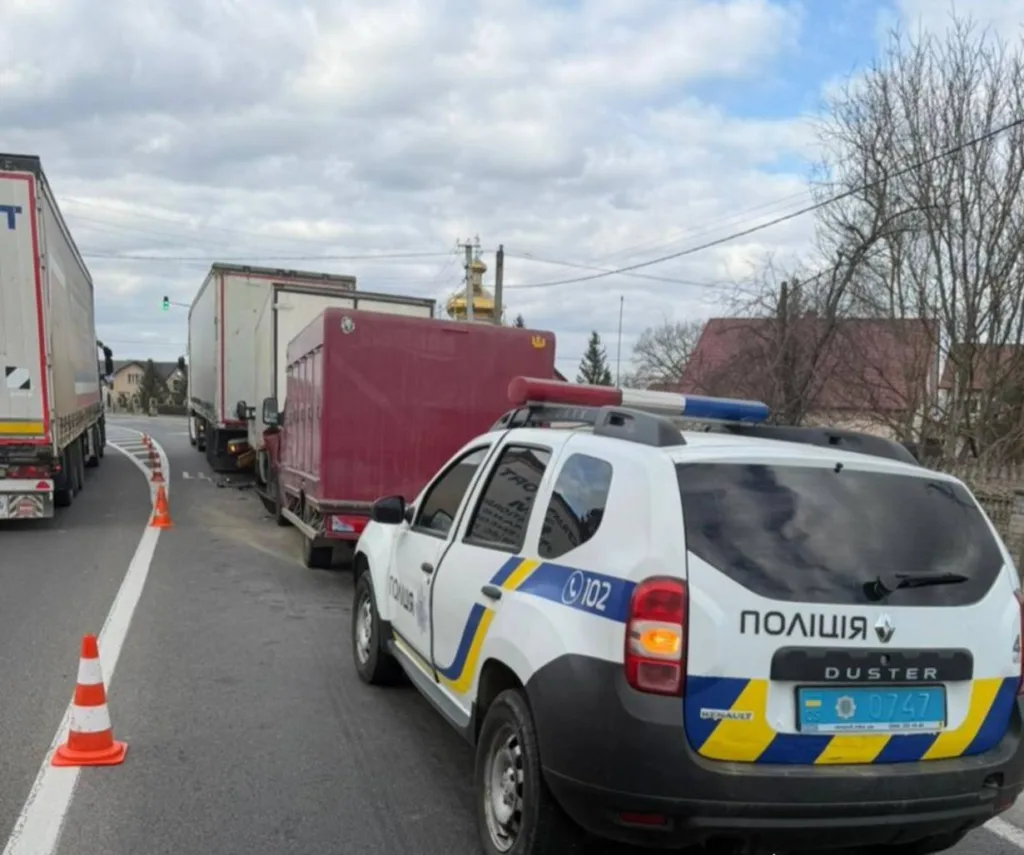 Поліцейський автомобіль біля вантажівок на дорозі