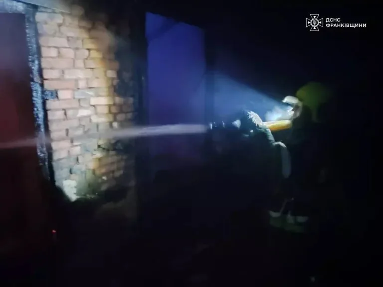 Пожежник гасить вогонь у цегляній будівлі