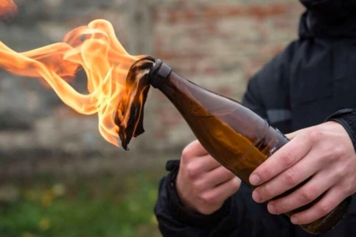 Людина тримає пляшку із запаленим ганчір'ям